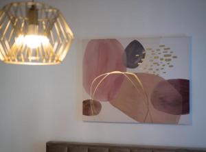 a painting on a wall next to a light fixture at Apartment Kona in Ivanja Reka