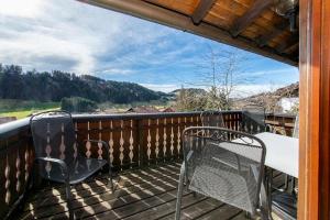 a balcony with two chairs and a table on a deck at Ferienwohnung Enzian 4 im Feriendorf Sonnenhang im Allgäu in Missen-Wilhams