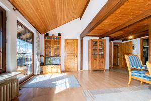 a living room with a wooden ceiling and a table at Ferienwohnung Enzian 4 im Feriendorf Sonnenhang im Allgäu in Missen-Wilhams
