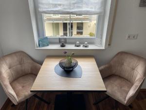 een eettafel met 2 stoelen en een raam bij Melli‘s Seenahe Ferienwohnung in Langenargen