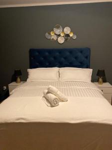 - un lit avec une tête de lit bleue et des serviettes dans l'établissement Ferienwohnung Mark, à Plauen