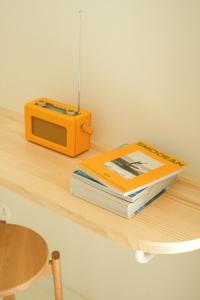 a book and a radio sitting on a table at Hotel des Dunes in Cap-Ferret
