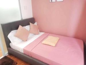 a pink and white bed with two pillows on it at Apartment-Serviced & Condo Free pool in Quezon City by Mi'Casa in Manila