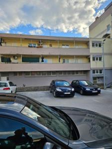 three cars parked in a parking lot in front of a building at Apartman Noa in Knin