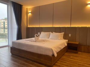 a bedroom with a large bed with a large window at Ho Tram Golden Hotel in Ho Tram