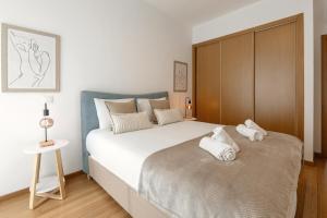 a bedroom with a large bed with towels on it at Golden Terrace Delight in São Martinho do Porto +26 photos