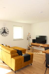 a living room with a couch and a flat screen tv at ADA, Ferienwohnung, 6-8 Personen, Parkplatz am Haus, modern, mit Dachterrasse in Kulmbach