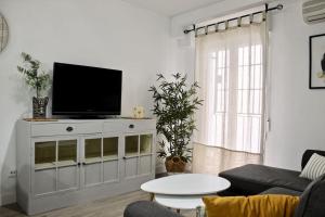 a living room with a flat screen tv on a cabinet at Centro Plaza San Miguel in Córdoba