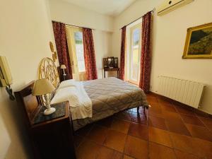 een slaapkamer met een bed en een tafel en ramen bij Penthouse Duomo in Cefalù