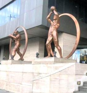 a statue of two men with hoops in front of a building at Apartment-Serviced & Condo Free pool in Quezon City by Mi'Casa in Manila