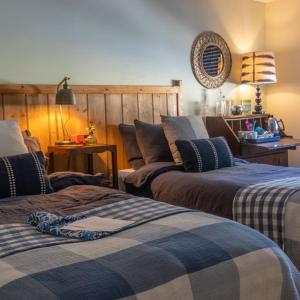 a bedroom with three beds with blue and white blankets at The Saxon Inn in Blandford Forum