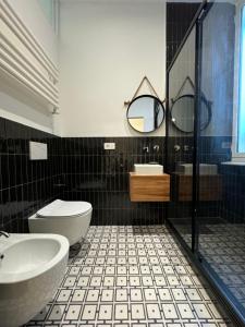 a black and white bathroom with a sink and a toilet at Noliday Savona Center Art Deco Apartment in Savona