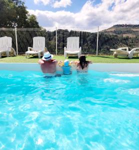 un homme et une femme assis dans une piscine dans l'établissement VAL ST GEORGES, à Saint-Georges-de-Luzençon