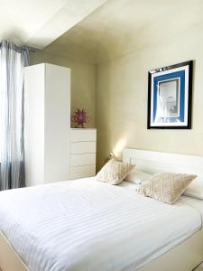 a bedroom with a large bed with white sheets at ComeCasa San Secondo White in Asti