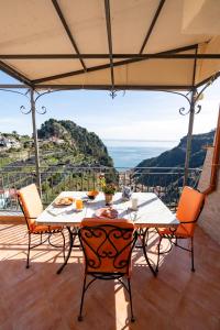 una mesa y sillas en un balcón con vistas en Il Paradiso sul Mare Apartment, en Scala