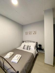 アテネにあるDima Rooms And Apartmentsのベッドルーム1室(ベッド1台、タオル2枚付)
