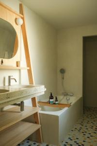 a bathroom with a sink and a bath tub at Hotel des Dunes in Cap-Ferret