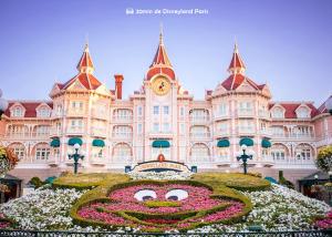 ein großes Gebäude mit einer Blumenuhr davor in der Unterkunft Bed & Breakfast - Entre Paris & Disneyland in Roissy-en-Brie