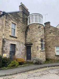 an old brick building with a water tower on top of it at Turret Town House in Hawick