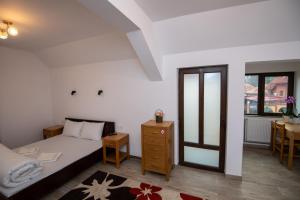a bedroom with a bed and a table and a window at Pensiunea Teona in Târgu Ocna +28 photos