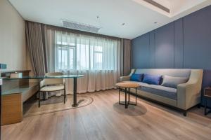 uma sala de estar com um sofá e uma mesa em Atour X Hotel Dongguan Chang'an Wanda em Dongguan