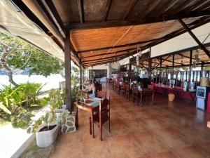 a restaurant withoccupied tables and chairs and tables and tablesktop at Doublegem Beach Resort and Hotel in El Nido