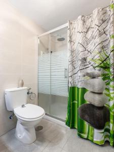 een badkamer met een toilet en een glazen douche bij Martiánez Playa: Coastal Location in Puerto de la Cruz