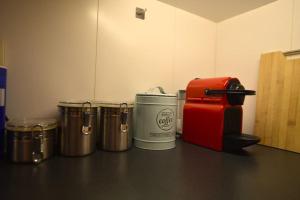 a counter top with four metal buckets and a red box at Leuven Centrum Comfort in Leuven