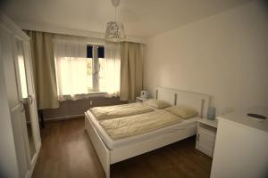 1 dormitorio con cama blanca y ventana en Leuven Centrum Comfort, en Lovaina