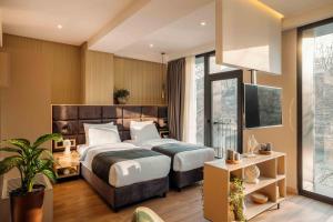 Habitación de hotel con 2 camas y TV en Hotel Monday by DNT Group en Tiflis
