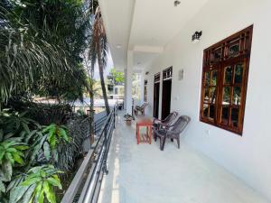 een balkon van een huis met stoelen en planten bij Baywatch Arugambay in Arugam Bay