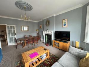 uma sala de estar com um sofá e uma mesa em Silverdale Apartments em Eastbourne