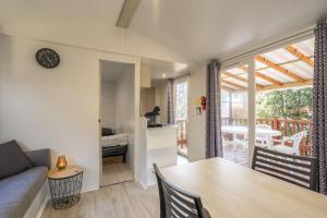 a kitchen and living room with a table and a couch at Mobil home La Palmyre in Les Mathes