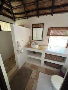 a bathroom with a sink and a mirror at Mango Beach Resort in Praia do Tofo