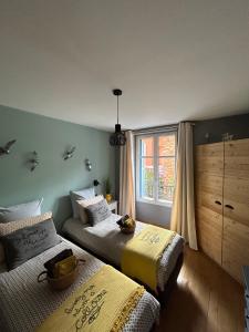 a bedroom with two beds and a window at L'équinoxe in Collioure