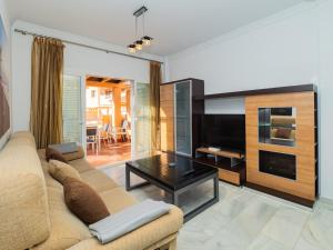 a living room with a couch and a television at Cubo's Cabopino Beach Marbella Apartment in Marbella