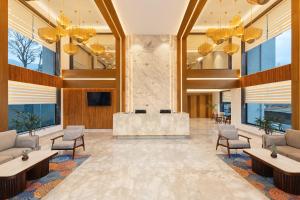 a lobby with a reception desk in a building at INFINITEA CENTRIC DHARAMSHALA in Dharamshala