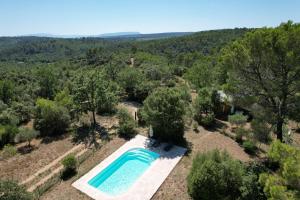 an overhead view of a swimming pool in a field with trees at Chalet dans plusieurs hectares de nature in Barjols