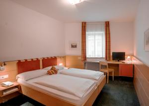 una camera con letto e scrivania con computer di Hotel Figl ***S a Bolzano