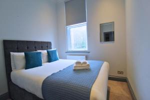 um quarto com uma cama com duas toalhas em Barons Court by Viridian Apartments em Londres