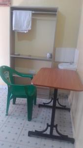 un tavolo e una sedia verde in una stanza di THE FARM BAR AND RESTAURANT a Kiminini