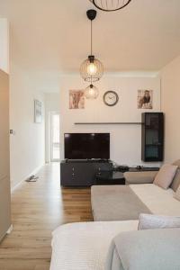 salon z kanapą i telewizorem z płaskim ekranem w obiekcie Apartment w Brukseli