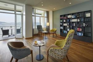 a living room with chairs and a book shelf at Zentrum Elisabeth in Walchwil
