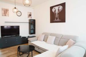 salon z kanapą i telewizorem w obiekcie Apartment w Brukseli