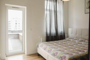 sypialnia z łóżkiem i dużym oknem w obiekcie Apartment w Brukseli