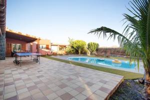 un patio con una mesa y una piscina en Villa Masé Fuerteventura, en La Asomada