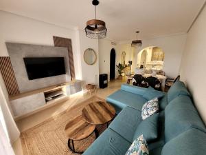 a living room with a blue couch and a table at Fantástico Ático Chill Out con Vistas a Mar de Cristal in Mar de Cristal