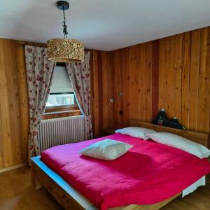 1 dormitorio con 1 cama grande con manta roja en Casa Alfredo en Cogne