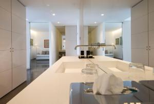 a white kitchen with a sink and a mirror at Bellevue San Lorenzo (Adults Only) in Malcesine