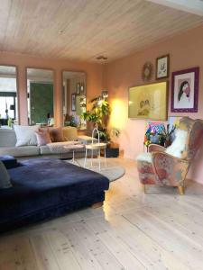 uma sala de estar com um sofá e uma cadeira em Sommerparadis på Nesbru - 5 min å gå til stranden em Asker